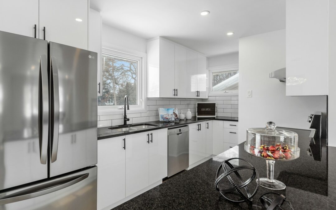 A photo of a kitchen with a refrigerator and white cabinets